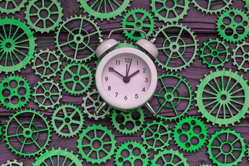 Alarm clock, gears on a wooden background. time, mechanism. action.