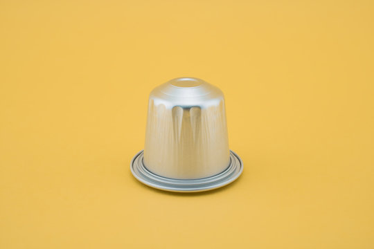 Espresso coffee capsule or coffee pod on yellow background. Isolated.