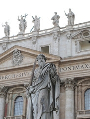 Fototapeta na wymiar Staue of Saint Paul with sword and the Basilica of Saint Peter i
