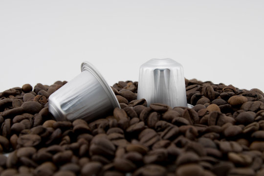 Coffee capsules or coffee pods on coffee beans, white background. Capsules.