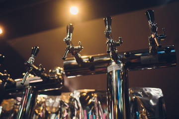 The bar counter with bottles and apparatus for dispensing beer. Apparatus for dispensing beer at the bar. Pub. The bar in the restaurant. Apparatus for dispensing beer in a restaurant.