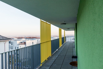 corridor outside of a building with colorful wall and railing