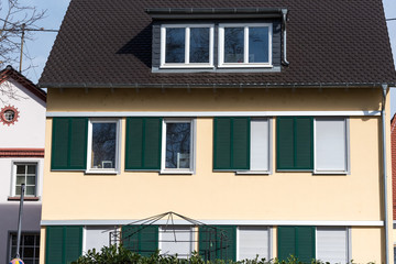 city house with green window shutters and a dark roof