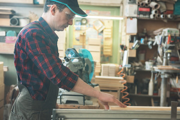 Carpenter worker cutting wooden board