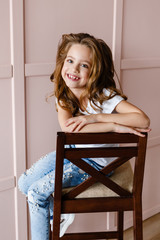 Portrait of a beautiful little girl on a pink background