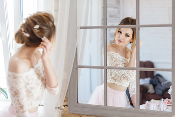 cute bridesmaid looks at herself in the mirror