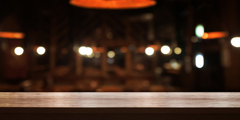 Empty wooden table top with blur coffee shop or restaurant interior background, Panoramic banner. Abstract background can be used for display.
