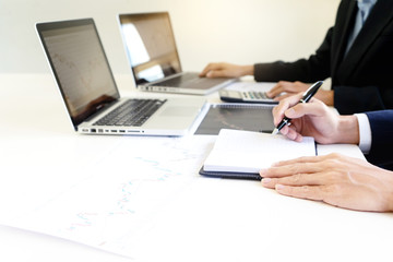business man and woman sit at ther table looking at computer laptop