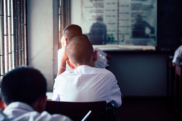 Fototapeta premium Students reading and writing answer doing exam in classroom with stress