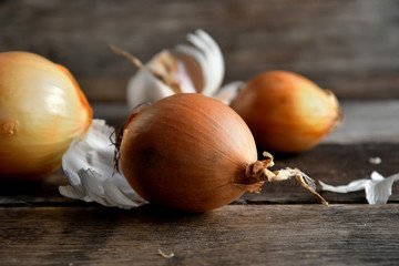 Onions and garlic on a wooden background.