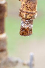 Old rusty tap with a drop of water. Macro shot