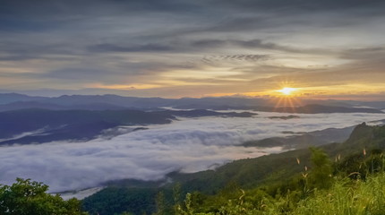 Mountain view morning of the hills around with sea of mist and soft yellow sun light in the sky background, sunrise at Doi Samur Dao, Sri Nan National Park, Nan, Thailand.