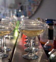 Glasses of champagne lined up on a bar. Bokeh in background.