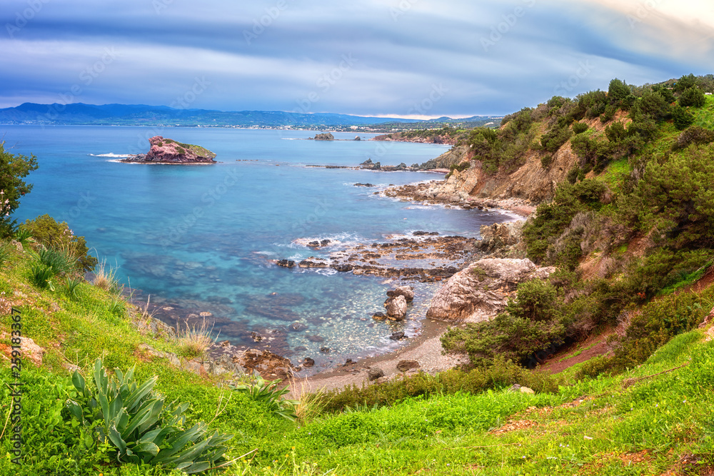 Wall mural amazing nature landscape, rocky seacoast with green grass and emerald colored crystal clear water of