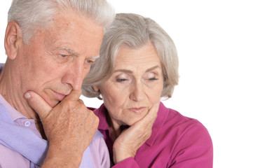 Portrait of sad senior couple on white background