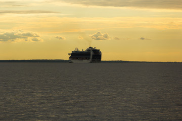 Cruise ship in the Gulf of Finland on a background of golden sky