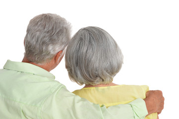Rear view of senior couple hugging on white background