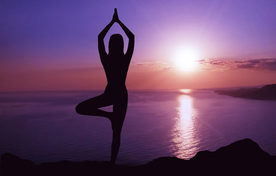 Woman practicing yoga at sunset. © Prostock-studio