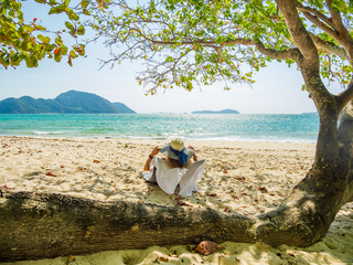 Woman enjoying her holidays on a transat at the tropical beach