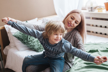 Playful family. Happy young mother having fun with her son