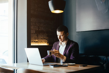 Young handsome businessman conducting negotiations with investors. Electronic business. Alternative...