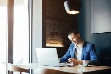 Young handsome businessman conducting negotiations with investors. Electronic business. Alternative...