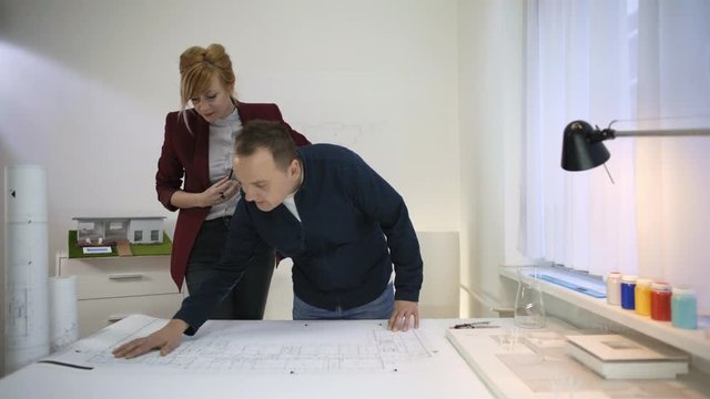 Two architects looking at a blueprint of a house