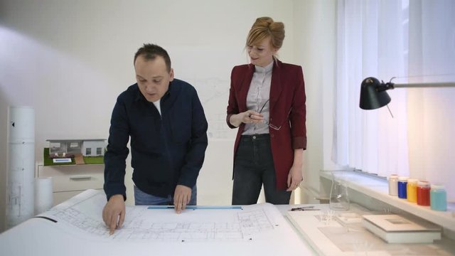 Two architects looking at a blueprint of a house