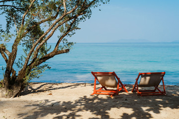 Luxury beach resort, beach loungers near the sea with white sand over sea Topical island...