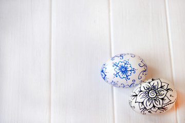 Two painted eggs on a white wooden background, the symbol of Easter
