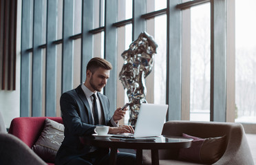 Young handsome businessman conducting negotiations with investors. Electronic business. Alternative...