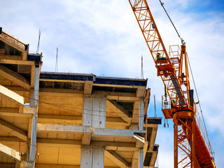 Fototapeta na wymiar Concrete building under construction. Crane and building activity. Construction site.