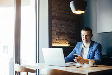 Young handsome businessman conducting negotiations with investors. Electronic business. Alternative...