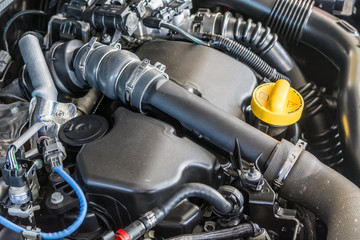 Brand new diesel car engine. Close up details of pipes, cables, oil cap. Off road vehicle components under the hood. 