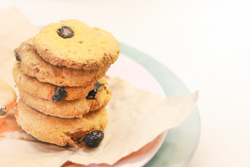 Cookies with raisins on a pink plate. Packing cookies in Kraft paper.