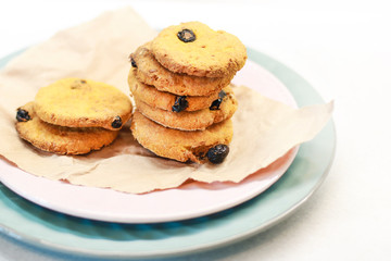 Fototapeta na wymiar Cookies with raisins on a pink plate. Packing cookies in Kraft paper.