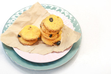 Cookies with raisins on a pink plate. Packing cookies in Kraft paper.
