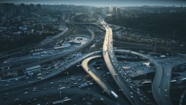 Night Aerial Urban Traffic Road System. Busy Downtown Route Development City Highway Junction Overview. Cityscape Car Motion Transport. Dark Blue Cinematic Filter. Concept Drone Flight Footage 4K, UHD