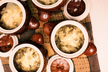 Clay pot with food inside - potatoes with mushrooms and vegetables and cheese
