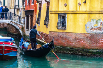 Fototapeta na wymiar Traditional canal street with gondolier in Venice, Italy