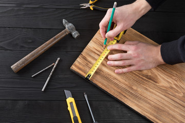 The carpenter works with wood on his workspace