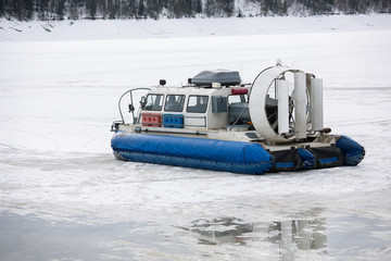 Hovercraft transporter on the ice of river in winter day