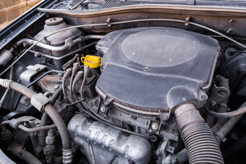 Top view under the hood of an old used gasoline engine with rusty and dirty auto parts, dust accumulation and bad car maintenanace. 