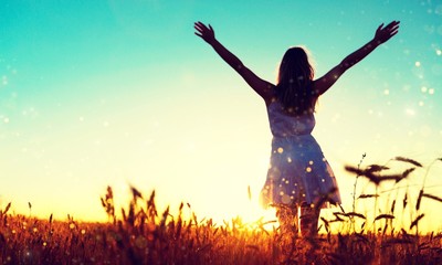 Young woman on field under sunset light