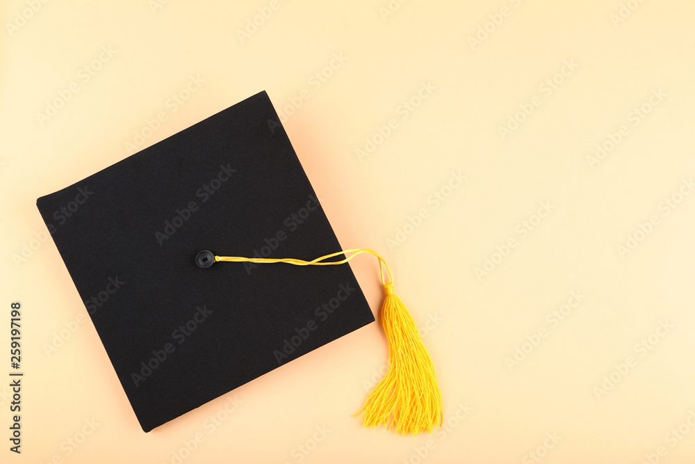 Wall mural Graduation cap on beige background