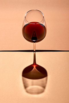 Wine glass reflected on beige background