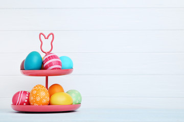 Stand with colorful easter eggs on white background
