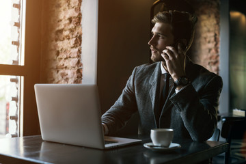 Young handsome businessman conducting negotiations with investors. Electronic business. Alternative...