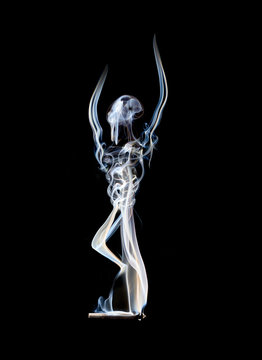 Woman made of smoke practicing yoga against black background