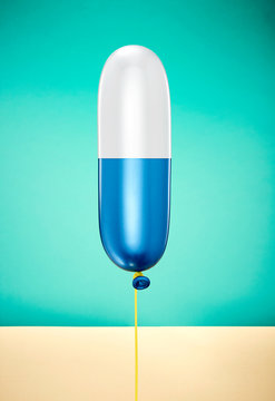 Inflated capsule shape balloon against turquoise background